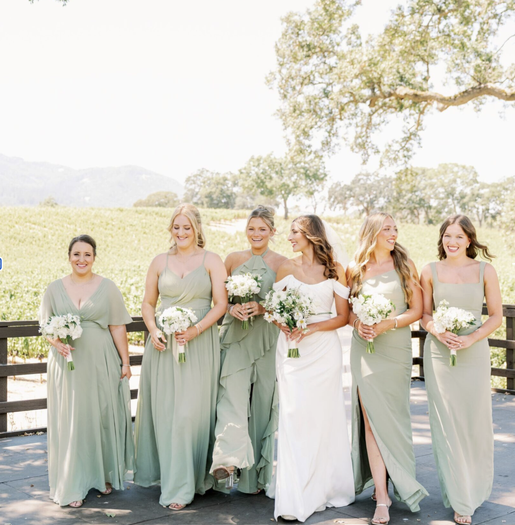 Bride and bridesmaids gathered on the amphitheater deck with the estate behind them
